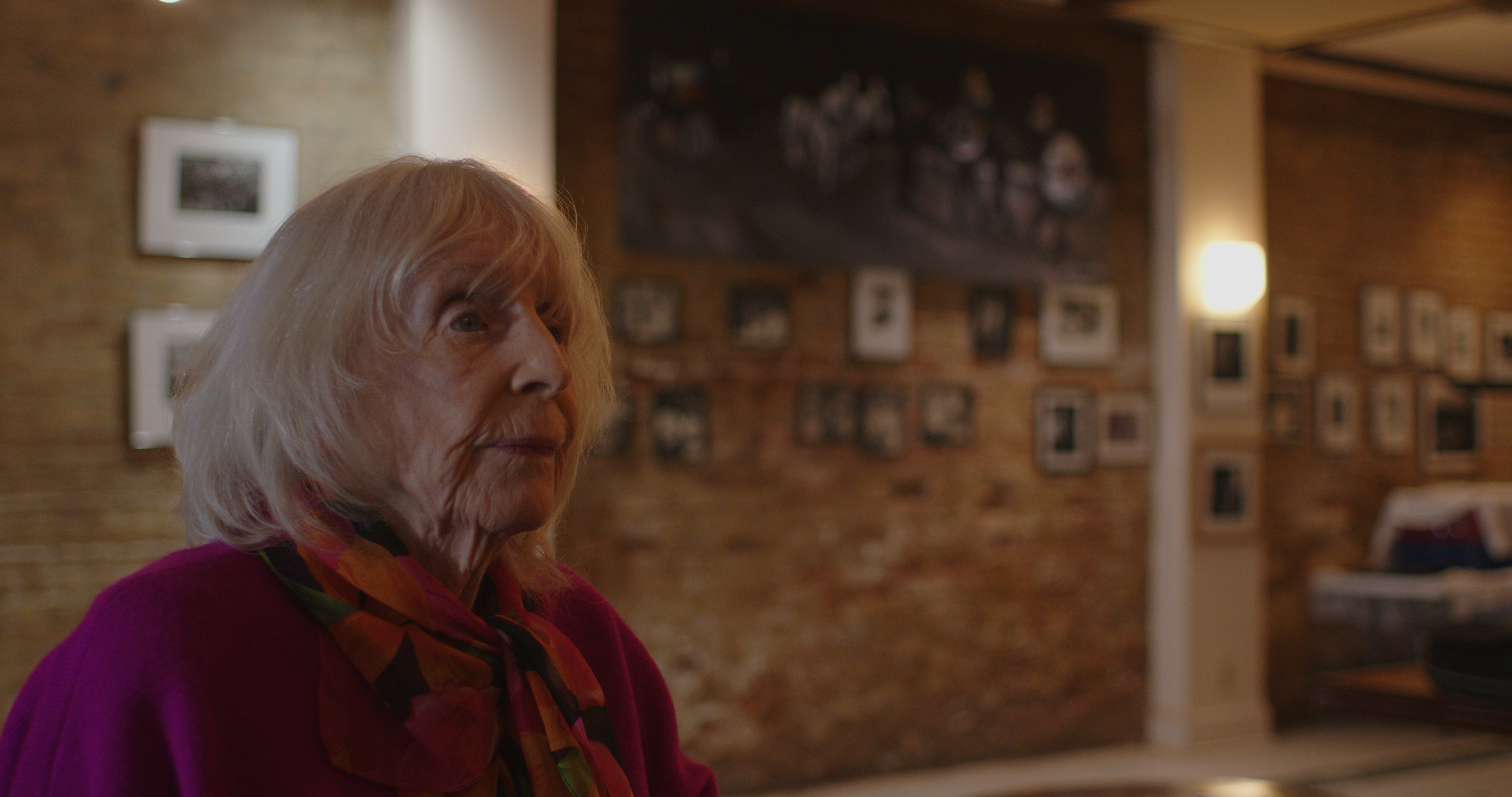 Nina Buck reflects, Palm Court photo wall in background