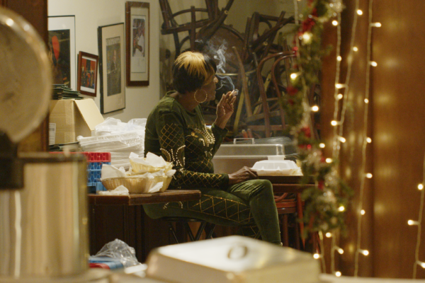 Woman smoking in back room, seen through doorway