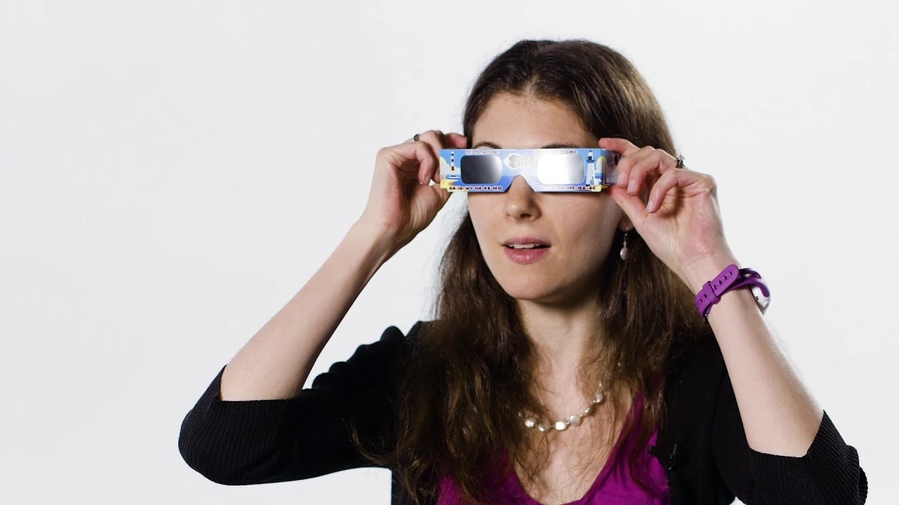 Woman wearing eclipse glasses wit white background